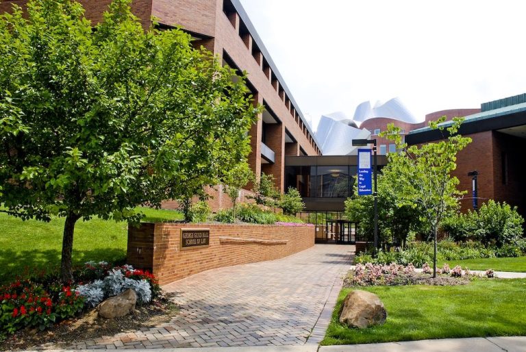 Entrance to George Gund Hall at Case Western Reserve University School of Law with a brick walkway, trees, and landscaped campus grounds.