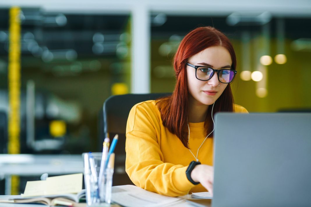 girl typing on laptop sitting at a desk