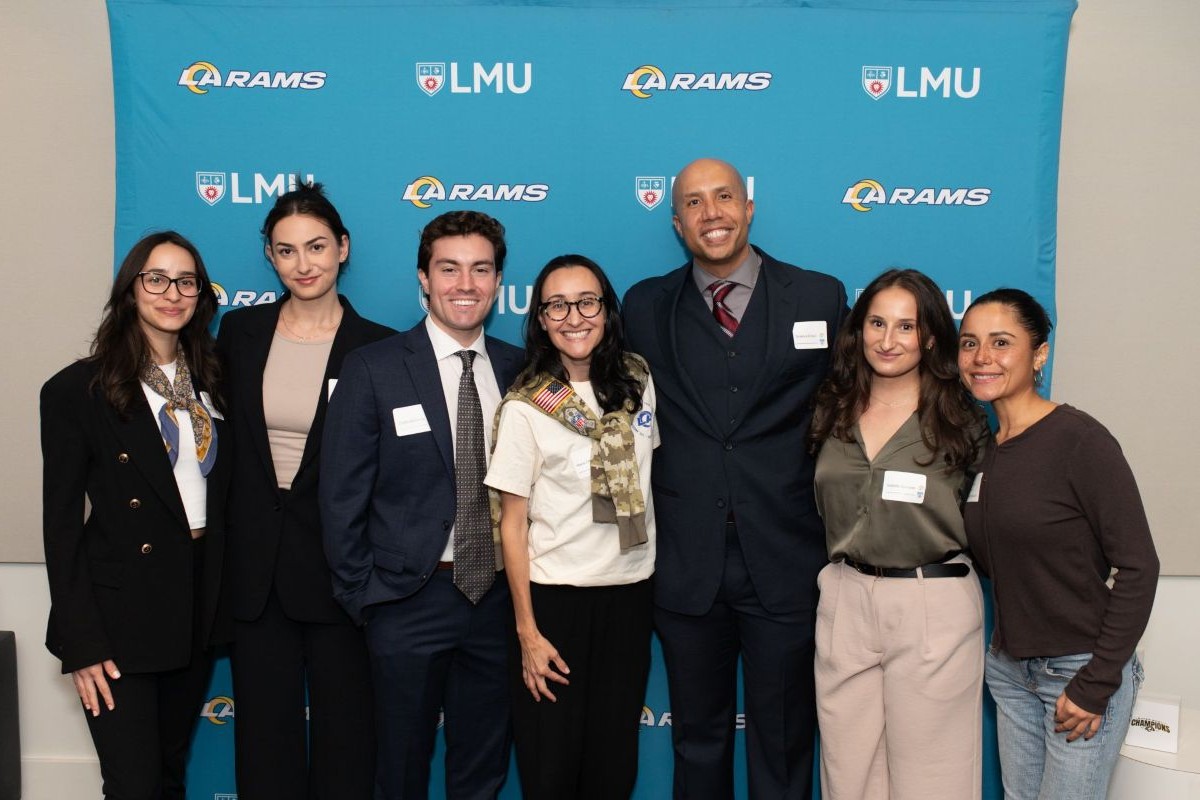 students standing in front of a LMU Loyola School of Law backdrop