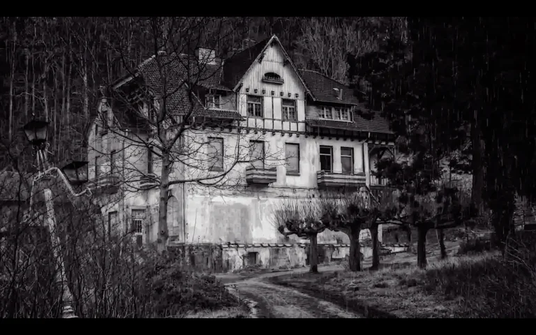 An old, abandoned house with boarded-up windows sits in a wooded area during rainfall, creating a dark and eerie atmosphere that suggests a haunted or neglected property.