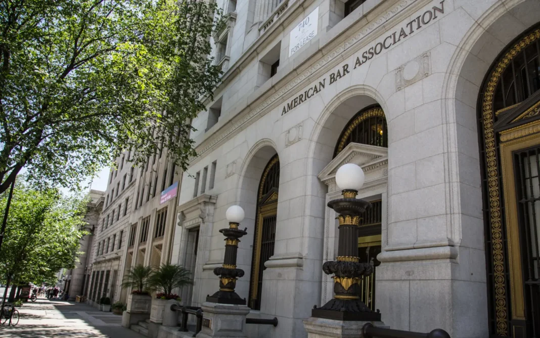 Exterior of the American Bar Association building with arched entrances, stone facade, and decorative street lamps along a tree-lined sidewalk.