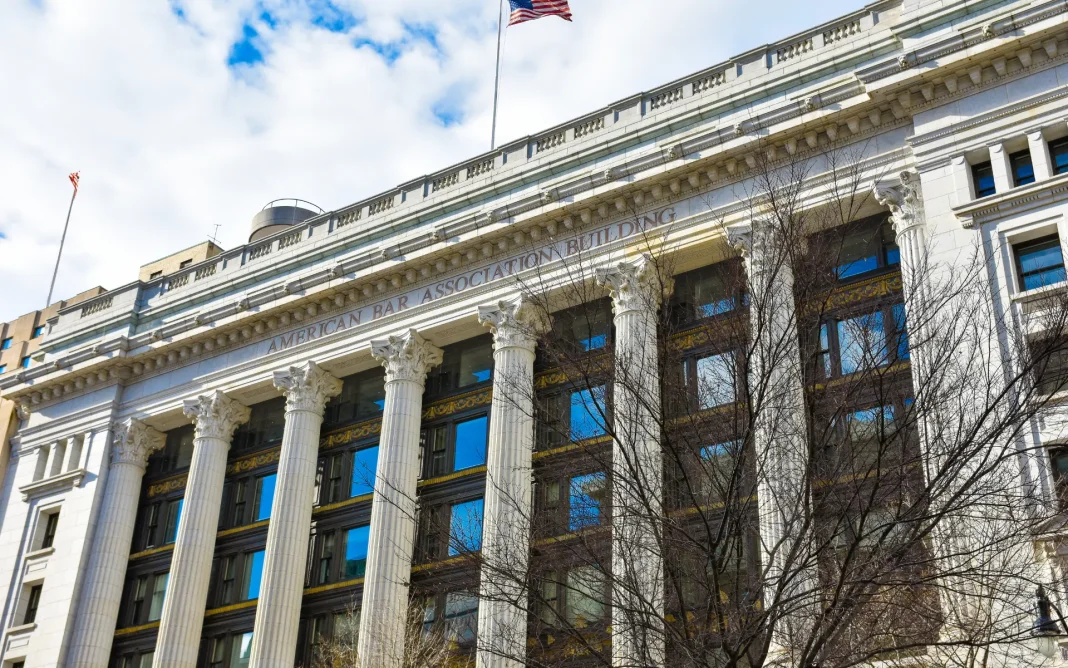 Exterior of the American Bar Association Building, a neoclassical structure with tall columns and an American flag flying above.