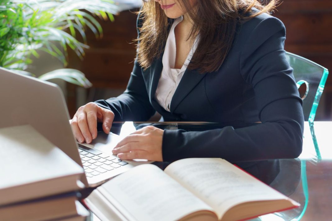 professional woman sitting at desk in front of laptop