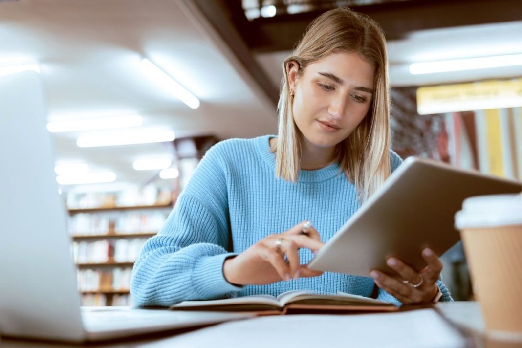 female college student at table in front of laptop
