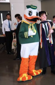 Oregon Duck poses for photos with recent law grads