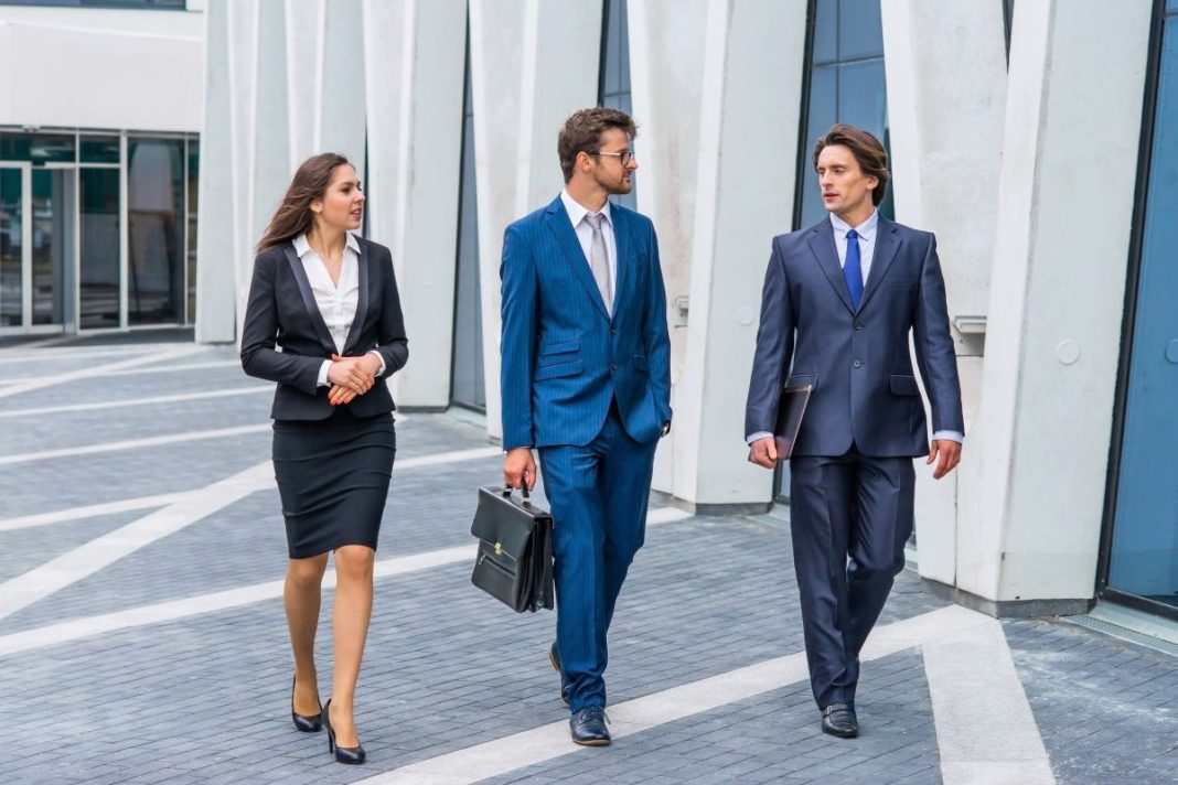 three professionals walking outside an metro office building