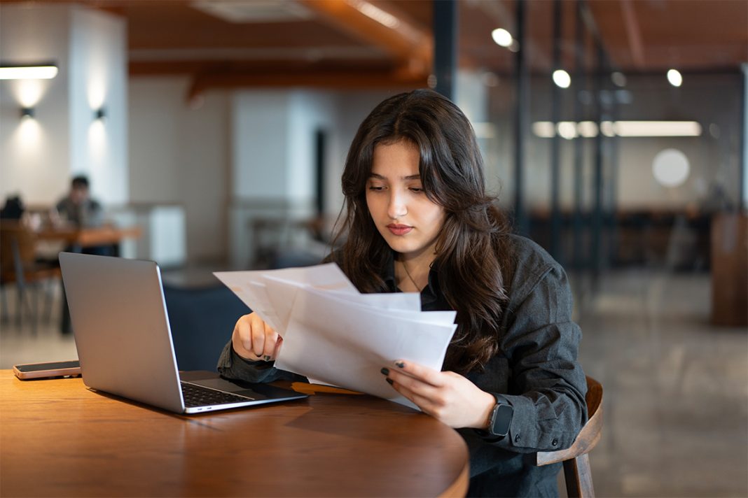 female sitting at a table in front of a laptop