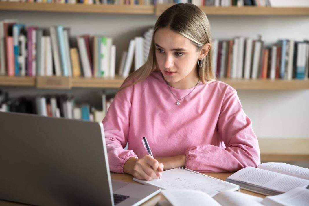 female sitting at desk in front of a laptop