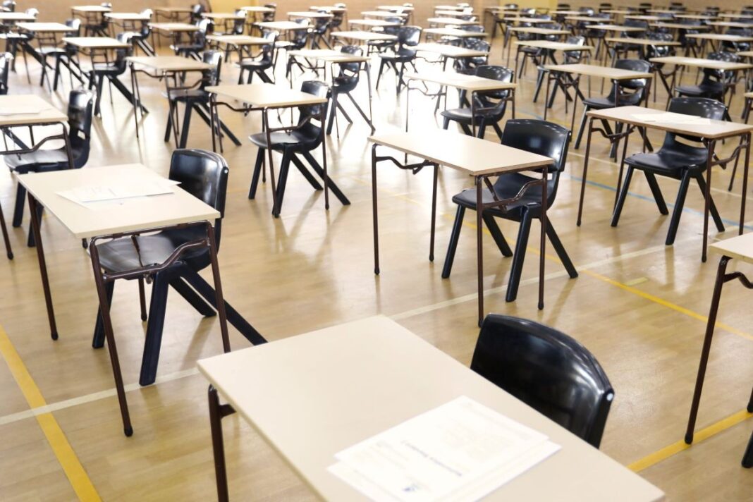 row of desks in an auditorium for testing